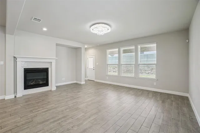 a view of an empty room with a window and fireplace