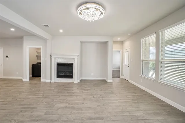 an empty room with windows and a fireplace