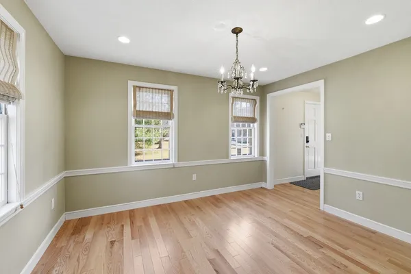 a view of empty room with wooden floor fan and window