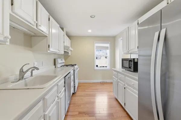 a kitchen with kitchen island granite countertop a sink and refrigerator