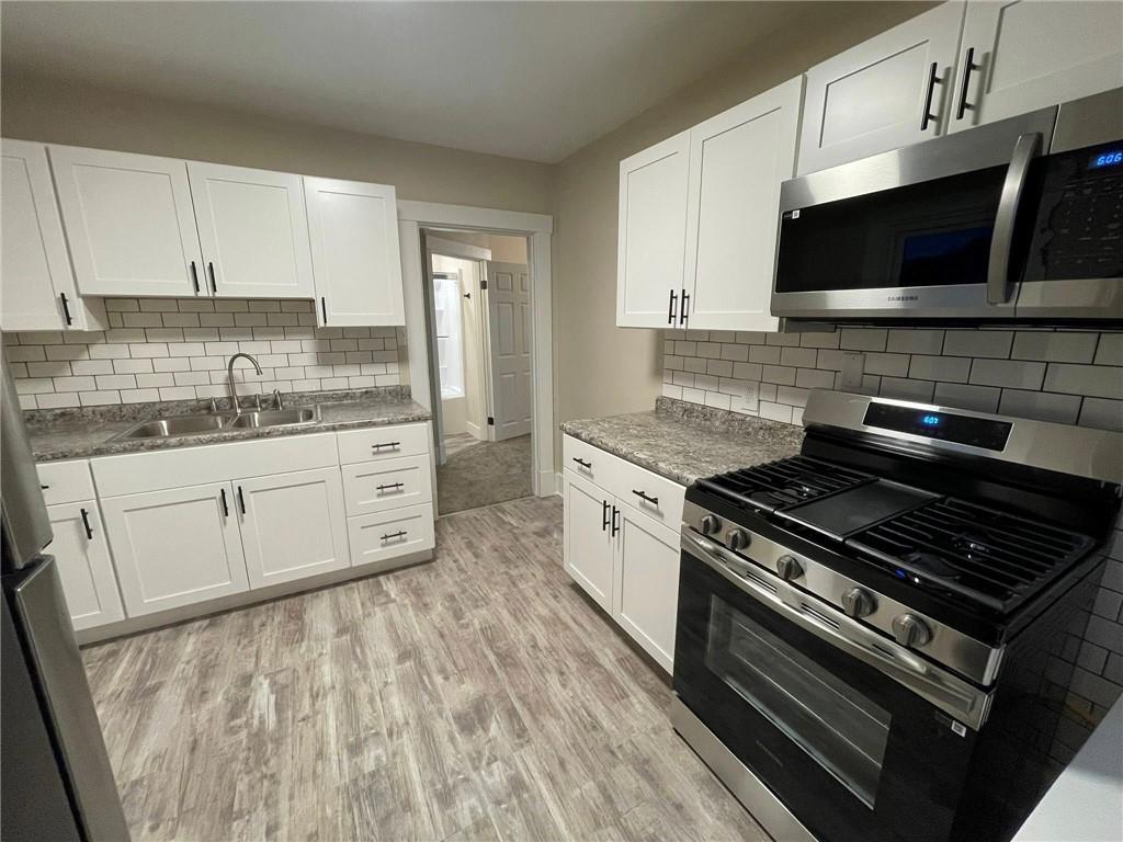 863 5th Avenue, Unit 2 Coraopolis, PA 15108 - Photo 1 of 17 a kitchen with stainless steel appliances kitchen island granite countertop a stove a sink and a microwave