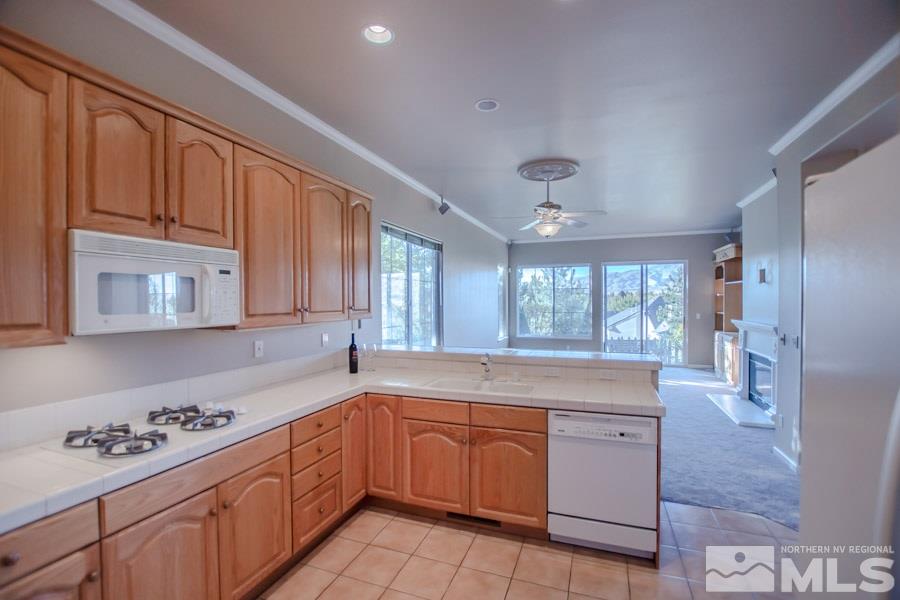 1815 Hunter Creek Road Reno, NV 89519 - Photo 8 of 25 a large kitchen with kitchen island granite countertop a sink window and cabinets