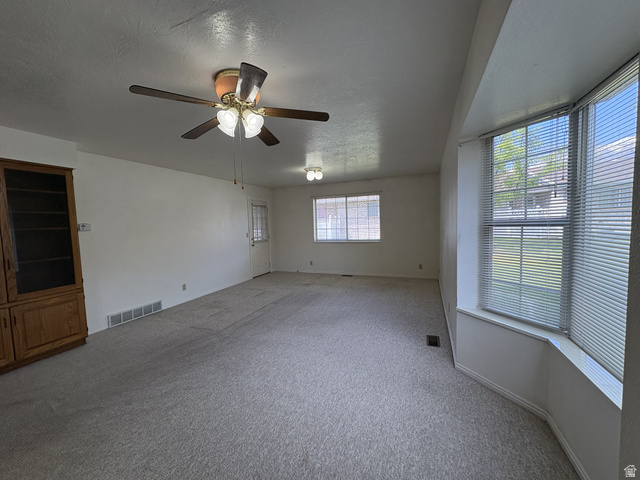 486 West 120 North Orem, UT 84057 - Photo 7 of 30 Spacious living area featuring light-toned carpeting and a ceiling fan with integrated lighting