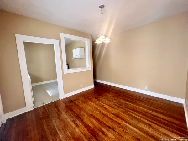 a view of empty room with wooden floor