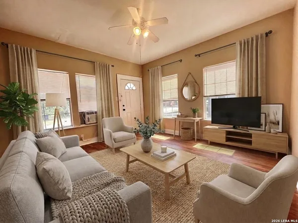 a living room with furniture a flat screen tv and a large window