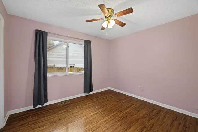 an empty room with wooden floor and door