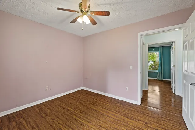 a view of empty room with wooden floor