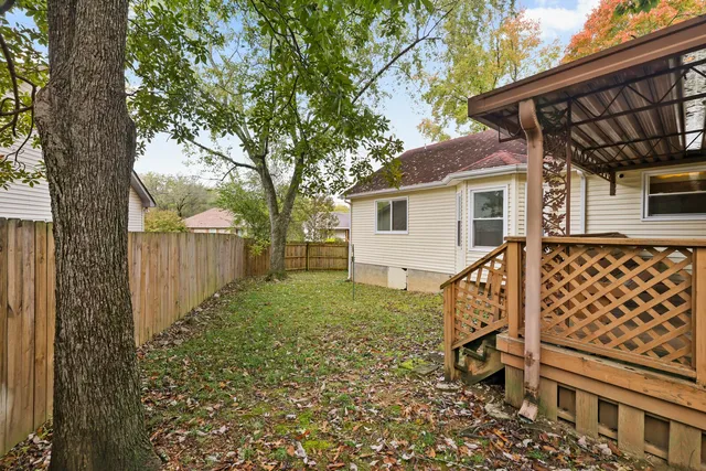 a view of a house with a small yard and wooden fence