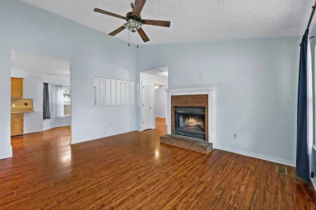 a view of empty room with wooden floor and fireplace