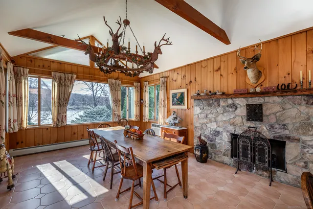a living room with furniture a fireplace and large windows