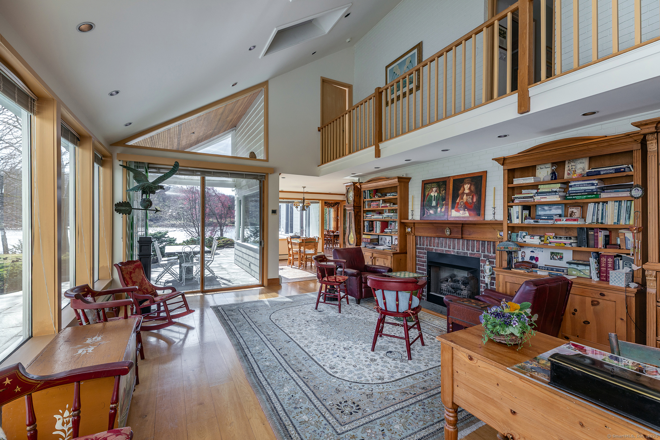 18 Arrow Point Road Warren, CT 06777 - Photo 18 of 30 a living room with furniture a fireplace and large windows