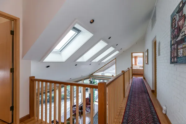 a bedroom with a bed and large window with wooden floor