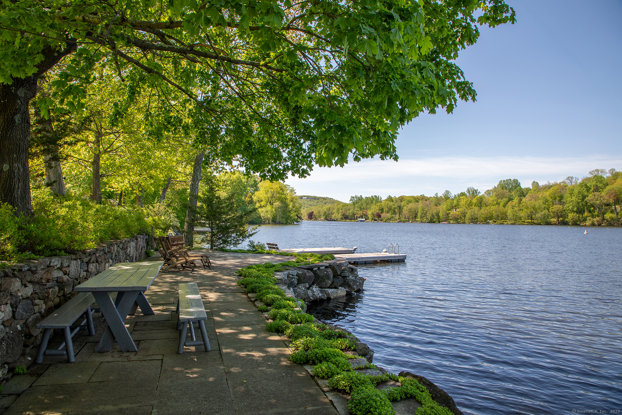 18 Arrow Point Road Warren, CT 06777 - Photo 7 of 30 a view of a lake with lawn chairs and wooden fence