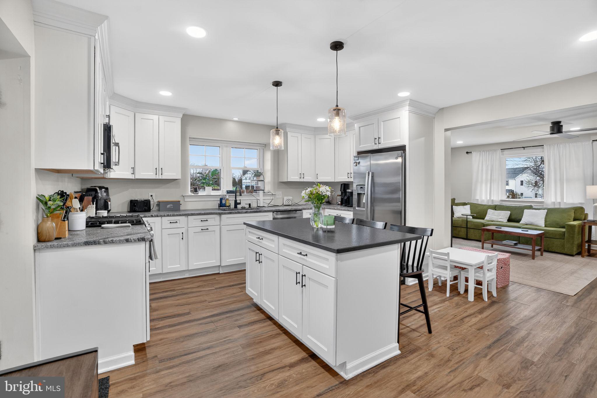516 Church Road Norristown, PA 19403 - Photo 14 of 31 a kitchen with stainless steel appliances granite countertop wooden floor sink stove and white cabinets with wooden floor