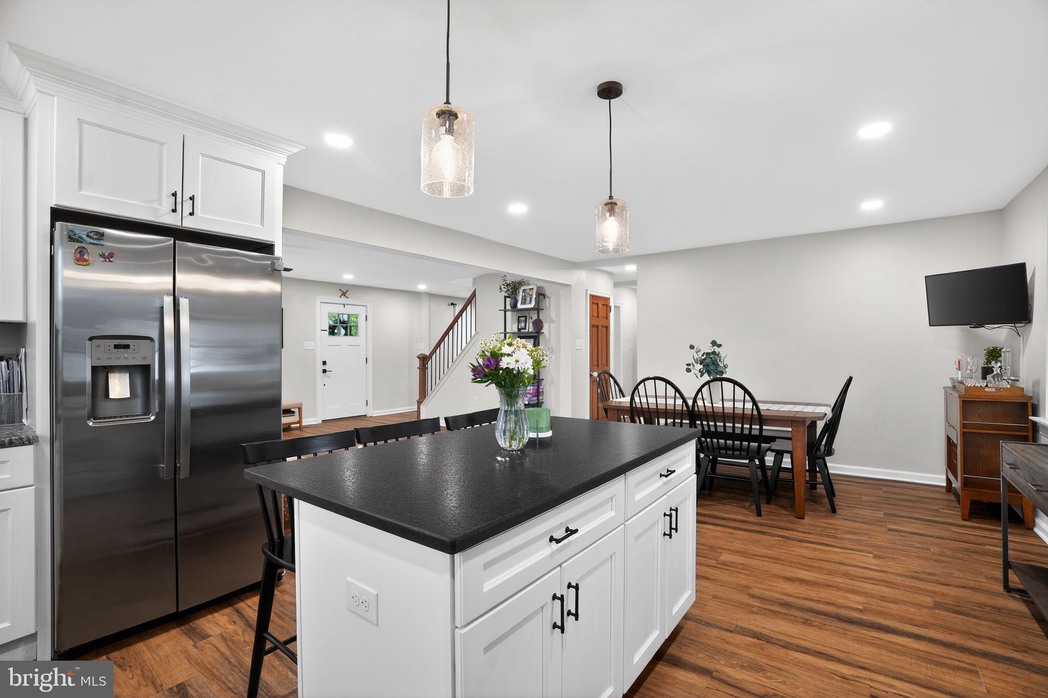516 Church Road Norristown, PA 19403 - Photo 16 of 31 a kitchen with stainless steel appliances granite countertop a table chairs refrigerator and wooden floor