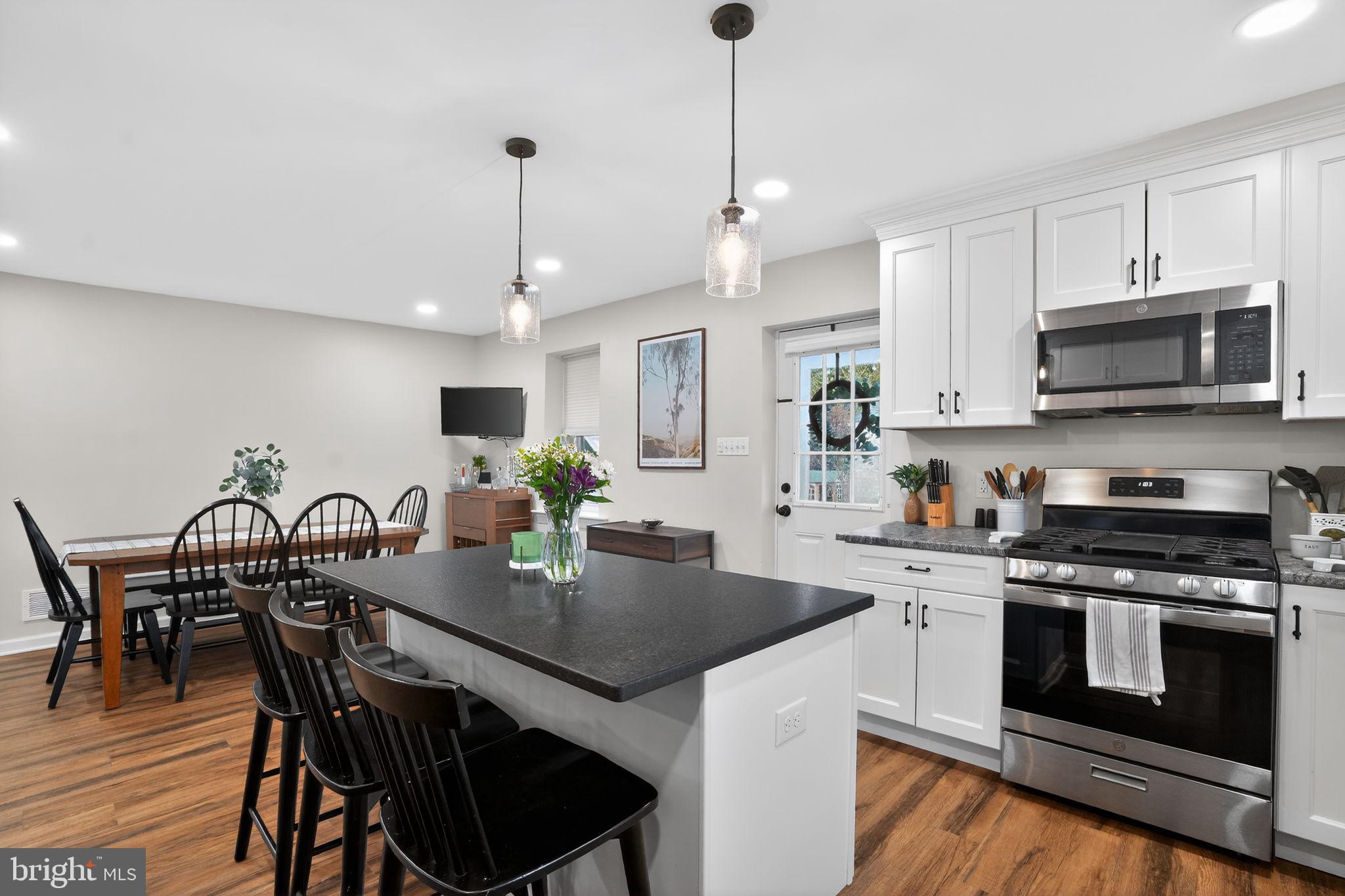 516 Church Road Norristown, PA 19403 - Photo 17 of 31 a kitchen with a stove a microwave a dining table and chairs