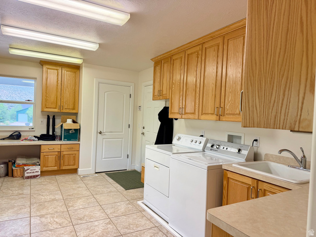 1133 Paris Canyon Road Paris, ID 83261 - Photo 31 of 75 Spacious utility area featuring extensive wood-finish cabinetry, a utility sink with a chrome faucet, light-toned tiled flooring, and multiple overhead fluorescent light fixtures
