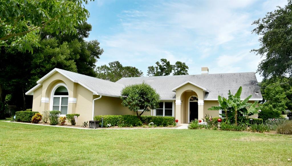 a view of a white house with a yard and potted plants