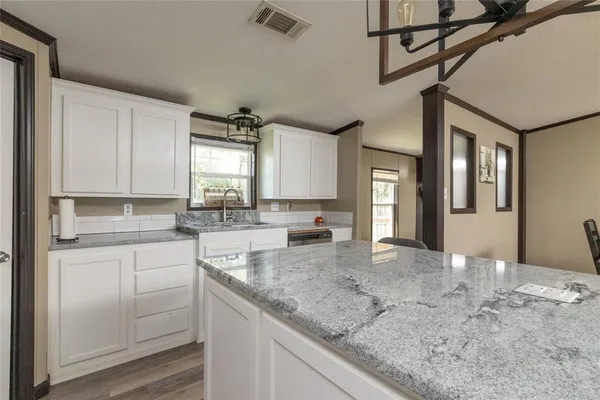 a kitchen with a sink window and cabinets