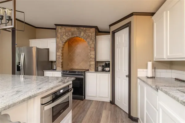 a kitchen with stainless steel appliances granite countertop a stove a refrigerator and a sink