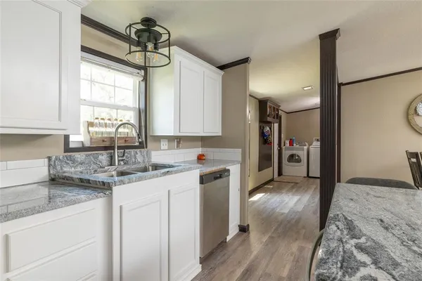 a kitchen with a sink cabinets stainless steel appliances and a window
