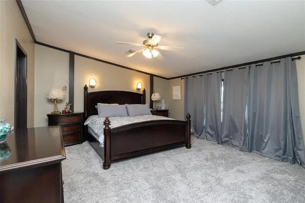 a spacious bedroom with a bed and a chandelier