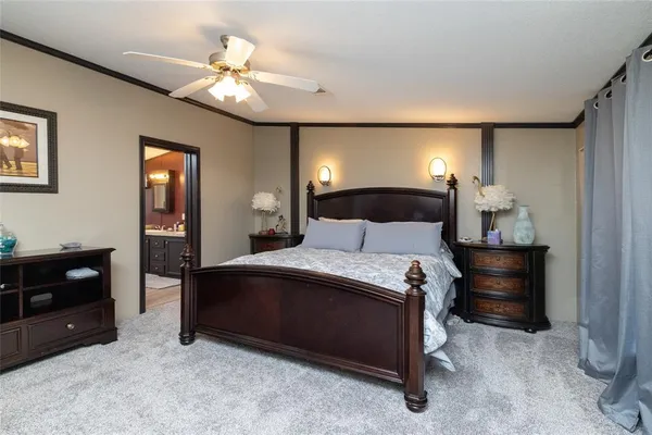 a bedroom with a bed and a lamp on dresser
