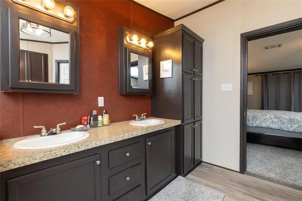 a en suite bathroom with a granite countertop sink and a mirror