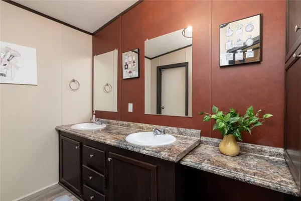 a bathroom with a granite countertop sink a mirror and a shower