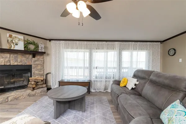 a living room with furniture a fireplace and a large window