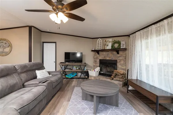 a living room with furniture a flat screen tv and a fireplace