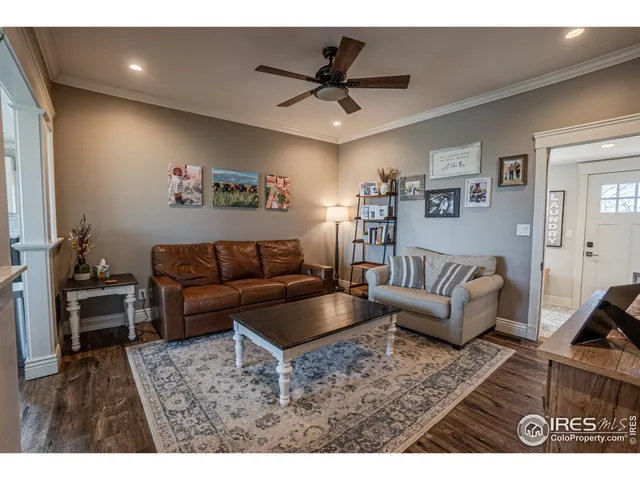 a living room with furniture and a dining table with wooden floor