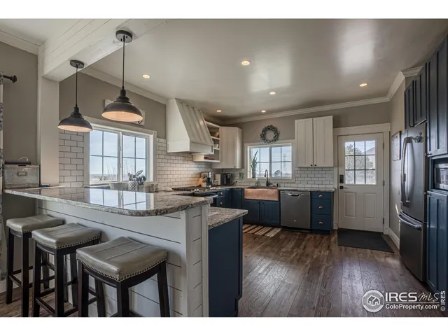 a kitchen with kitchen island a counter top space a sink stainless steel appliances and cabinets
