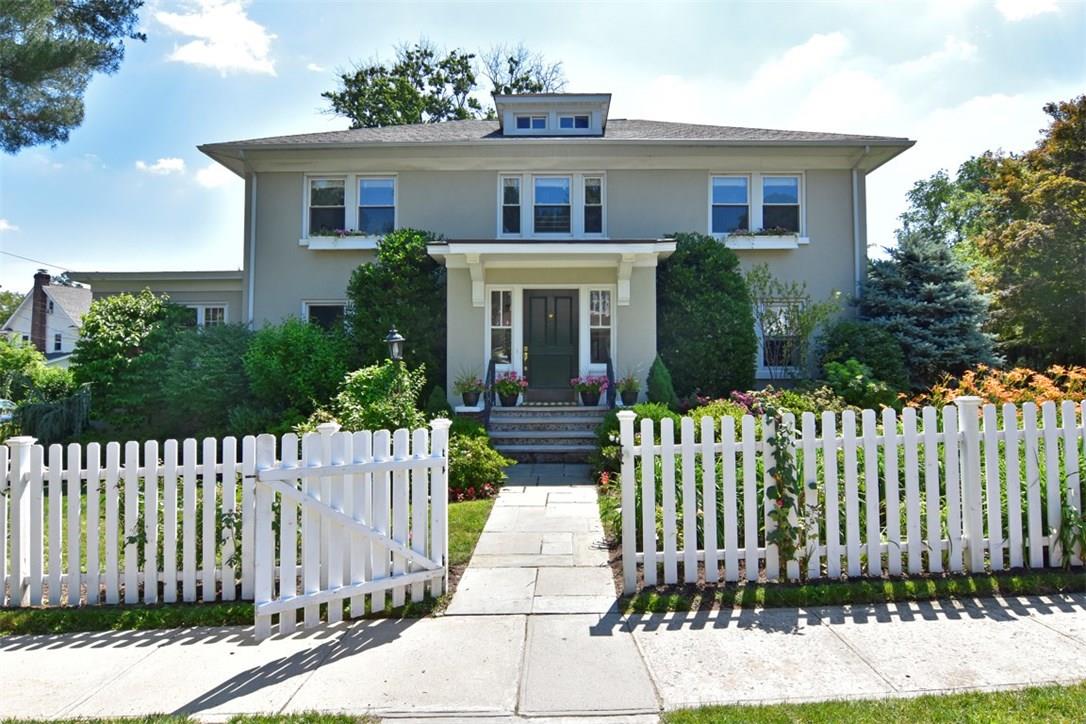 Classic Center Hall Colonial surrounded by charming white picket fence