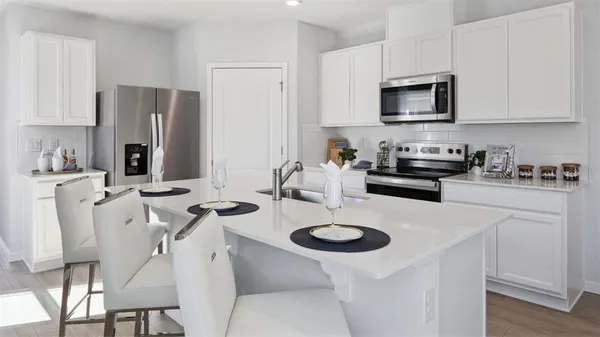 a kitchen with stainless steel appliances granite countertop a sink a stove a refrigerator and cabinets