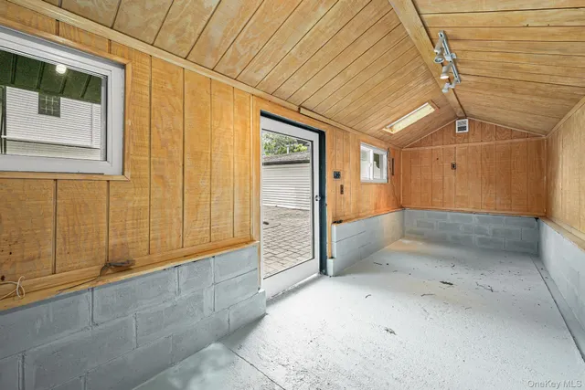 a picture of a bench in room with a window