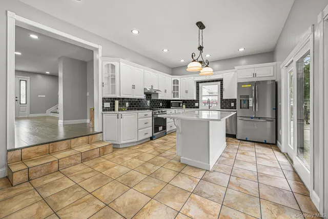 a kitchen with stainless steel appliances granite countertop a refrigerator and a stove top oven