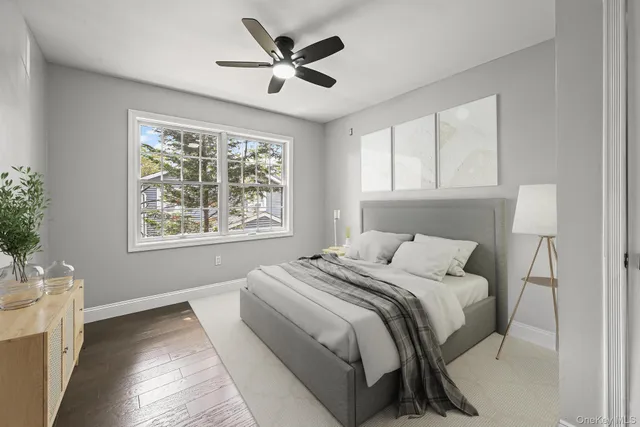 a bedroom with a large bed with wooden floor next to a window