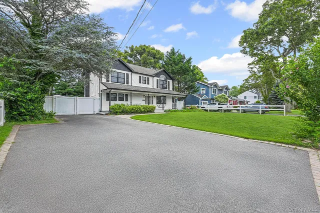 a view of a house with a big yard and large trees