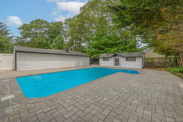 a view of backyard with wooden fence and large trees