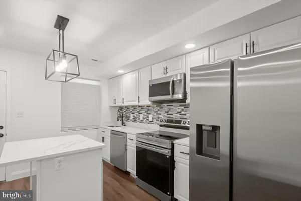 a kitchen with stainless steel appliances a sink and a refrigerator