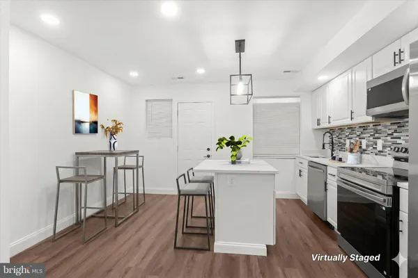a kitchen with white cabinets and stainless steel appliances