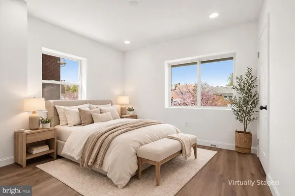 a bedroom with a large bed and a potted plant