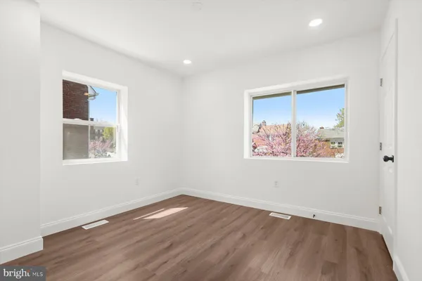 an empty room with wooden floor and window