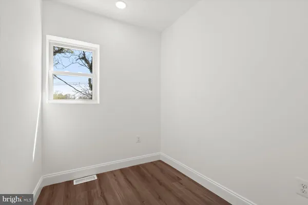 a view of a small space with wooden floor and a window