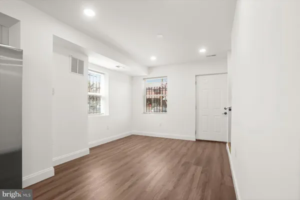 a view of a room with wooden floor and windows