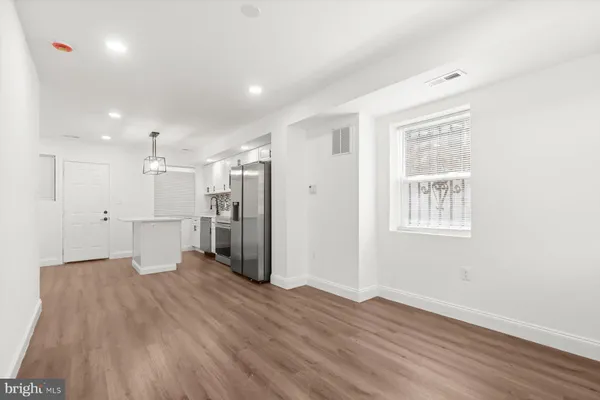 a view of a big room with wooden floor and a window