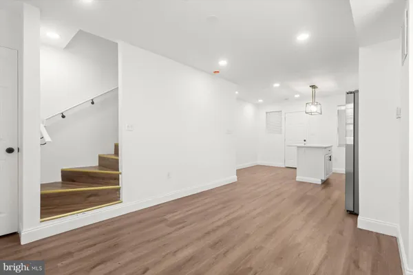 wooden floor in an empty room with a kitchen