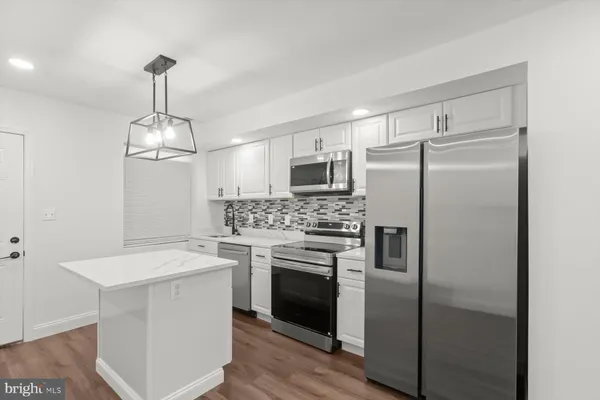 a kitchen with a refrigerator sink and cabinets