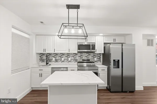 a kitchen with stainless steel appliances a microwave a sink and a refrigerator